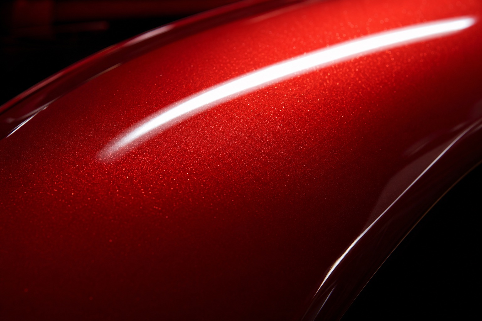 Extreme close-up of finished candy-apple red paint, metallic flake glittering under a strip light.
